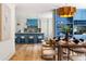 Stylish dining room featuring modern light fixture, blue built-ins, and an open kitchen concept at 1155 Peachtree Battle Nw Ave, Atlanta, GA 30327