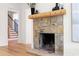 Rustic stone fireplace with wooden mantle, and hardwood flooring, complemented by natural light at 1155 Peachtree Battle Nw Ave, Atlanta, GA 30327