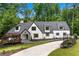 Stunning home with manicured lawn, long driveway, and striking architecture with modern, dark-trimmed windows at 1155 Peachtree Battle Nw Ave, Atlanta, GA 30327