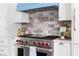A modern kitchen with stainless steel range, stylish backsplash, and white cabinets at 1155 Peachtree Battle Nw Ave, Atlanta, GA 30327