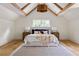 Beautiful main bedroom with vaulted ceiling, exposed beams, wooden light fixture, hardwood floors and large rug at 1155 Peachtree Battle Nw Ave, Atlanta, GA 30327