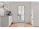 Bright mud room features a utility sink, white cabinetry, floating shelves, and a view of the backyard at 1155 Peachtree Battle Nw Ave, Atlanta, GA 30327