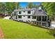 Rear exterior showcasing the lawn, patio, staircase, and screened-in porch at 1155 Peachtree Battle Nw Ave, Atlanta, GA 30327