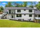 Backyard view of the home featuring a patio and expansive lawn and black-trimmed windows at 1155 Peachtree Battle Nw Ave, Atlanta, GA 30327