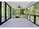 A lovely screened porch with black framed windows and doors provides serene view of surrounding greenery and trees at 1155 Peachtree Battle Nw Ave, Atlanta, GA 30327