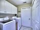 Bright laundry room with washer, dryer, storage cabinets, and white door at 174 Vintage Club Cir, Marietta, GA 30066