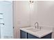 A stylish powder room features a blue vanity with quartz countertop and modern chrome fixtures, offering a sleek design at 2346 East Maddox Rd, Buford, GA 30518