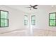 A bright bedroom with minimalist design features hardwood floors, white walls, black-trimmed windows, and a ceiling fan at 2346 East Maddox Rd, Buford, GA 30518