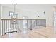 An elegant foyer showcases a staircase with black iron railings and modern lighting fixture and hardwood floors at 2346 East Maddox Rd, Buford, GA 30518
