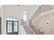 Grand foyer with staircase, light hardwood floors, and arched entry above the door at 2346 East Maddox Rd, Buford, GA 30518