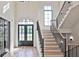 Elegant entryway featuring stairs with metal railings and a front door with arched window at 2346 East Maddox Rd, Buford, GA 30518