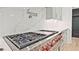 Gourmet kitchen with chef-grade gas range, stainless steel hood, and white quartz backsplash at 2346 East Maddox Rd, Buford, GA 30518