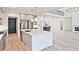 Open-concept kitchen with a quartz island, stainless appliances, and modern light fixtures overlooking the living area at 2346 East Maddox Rd, Buford, GA 30518