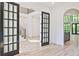 Spacious and bright, this living room boasts beautiful hardwood floors, a staircase, and black french doors at 2346 East Maddox Rd, Buford, GA 30518