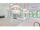 Bright living room with a fireplace, large windows, and three pendant lights over the island at 2346 East Maddox Rd, Buford, GA 30518