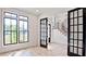 Inviting living room with large windows, hardwood floors, and glass paneled French doors leading to the staircase at 2346 East Maddox Rd, Buford, GA 30518