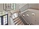 A bright foyer showcases an elegant staircase with black iron railings and modern lighting fixture and natural light at 2346 East Maddox Rd, Buford, GA 30518