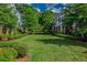 Lush backyard featuring a large manicured lawn, hedges and mature trees in a serene setting at 7455 Cordery Rd, Cumming, GA 30040