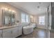 Bright bathroom with double sink vanity, soaking tub, and separate glass shower at 7455 Cordery Rd, Cumming, GA 30040