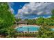 Resort-style community pool with a sundeck, mature landscaping, and a charming pool house at 7455 Cordery Rd, Cumming, GA 30040