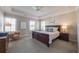 Spacious main bedroom with tray ceiling, carpet, and a large bed at 7455 Cordery Rd, Cumming, GA 30040