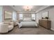 Serene main bedroom with neutral tones, a decorative chandelier, and dual windows for ample light at 7455 Cordery Rd, Cumming, GA 30040
