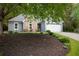 Charming single-Gathering home with stone accents and mature landscaping, including a lush lawn and vibrant flower beds at 1605 Barrier Rd, Marietta, GA 30066