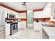 Well-lit kitchen featuring white cabinets, stainless steel appliances, and tile flooring at 1605 Barrier Rd, Marietta, GA 30066