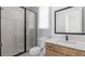 Modern bathroom with glass shower, white tiled walls, vanity with light wood cabinets, and sleek fixtures at 298 Tillman Pass, Woodstock, GA 30188