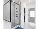 Modern bathroom with a glass-enclosed shower featuring a marble tile surround and sleek black fixtures at 298 Tillman Pass, Woodstock, GA 30188