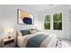 Relaxing bedroom featuring soft lighting, a plush bed with blue accents, and a view of the lush greenery outside at 298 Tillman Pass, Woodstock, GA 30188