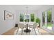 Bright dining room with modern chandelier, white table, large windows, and access to the backyard at 298 Tillman Pass, Woodstock, GA 30188