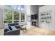 Sun-drenched living room boasts a fireplace, built-in bookshelves, and a wall of windows at 298 Tillman Pass, Woodstock, GA 30188