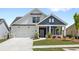 Charming two-story home featuring white and navy blue siding, a two-car garage, and a well-manicured lawn at 313 Sassafras Way, Holly Springs, GA 30115