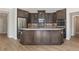 Kitchen island with a white countertop, dark brown cabinetry, stainless steel appliances, and hardwood flooring at 313 Sassafras Way, Holly Springs, GA 30115