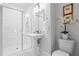 Modern bathroom with a glass-enclosed shower, pedestal sink, and contemporary lighting fixtures offering a clean aesthetic at 3408 Landen Pine Ne Ct, Atlanta, GA 30305