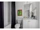 Bathroom with dark shower curtain, white fixtures, and framed art at 3408 Landen Pine Ne Ct, Atlanta, GA 30305