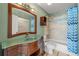 Unique bathroom with vessel sink, wood cabinet, custom mirror, and tub with shower at 610 Mill Pond Se Dr, Smyrna, GA 30082