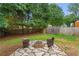 Backyard with stone patio featuring chairs and a built in fire pit with plenty of surrounding trees at 865 Ashfield Dr, Decatur, GA 30030