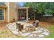 Backyard with stone patio featuring chairs and a built in fire pit with a covered pergola nearby at 865 Ashfield Dr, Decatur, GA 30030