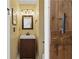 Charming half-bathroom featuring rustic wood sliding door, with vanity sink, adding a unique design element at 865 Ashfield Dr, Decatur, GA 30030