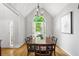Dining area with a large window, a long wooden table with seating, and hardwood floors at 865 Ashfield Dr, Decatur, GA 30030