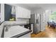 Modern kitchen with stainless steel refrigerator, white cabinets, and a view into the dining area at 865 Ashfield Dr, Decatur, GA 30030