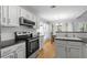View of the kitchen featuring white cabinets, a black electric stove, and a wooden dining table at 865 Ashfield Dr, Decatur, GA 30030