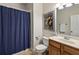 Cozy bathroom with a blue shower curtain, wood vanity, and framed Jazz Heritage Festival artwork at 2143 Yancey Ne Ln, Atlanta, GA 30319