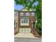 Inviting brick townhome featuring a two-car garage and a quaint entrance staircase leading to the front door at 2143 Yancey Ne Ln, Atlanta, GA 30319