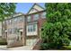 Attractive brick townhome featuring a two-car garage, bay window, and a welcoming entrance staircase at 2143 Yancey Ne Ln, Atlanta, GA 30319