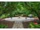 The landscaped butterfly garden boasts whimsical metal butterfly art, lush greenery, and a charming water feature at 2143 Yancey Ne Ln, Atlanta, GA 30319