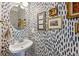 Chic powder room featuring patterned wallpaper, framed artwork, a stylish mirror, and a pedestal sink at 2143 Yancey Ne Ln, Atlanta, GA 30319