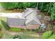 Expansive aerial view of a brick home with a landscaped backyard, patio, and lush greenery surrounded by mature trees at 2239 Tayside Nw Xing, Kennesaw, GA 30152